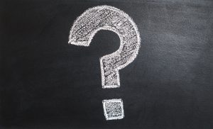 a guestion mark sign wriiten on a black board with chalk