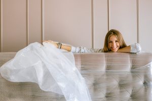 a woman smiling behind a headboard
