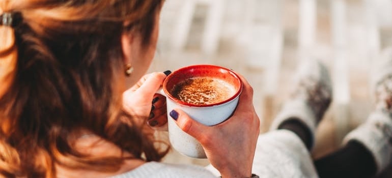 A woman drinking coffee at home.
